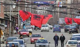 По улиците на Косовска Митровица висят албански и сръбски (в дъното) знамена