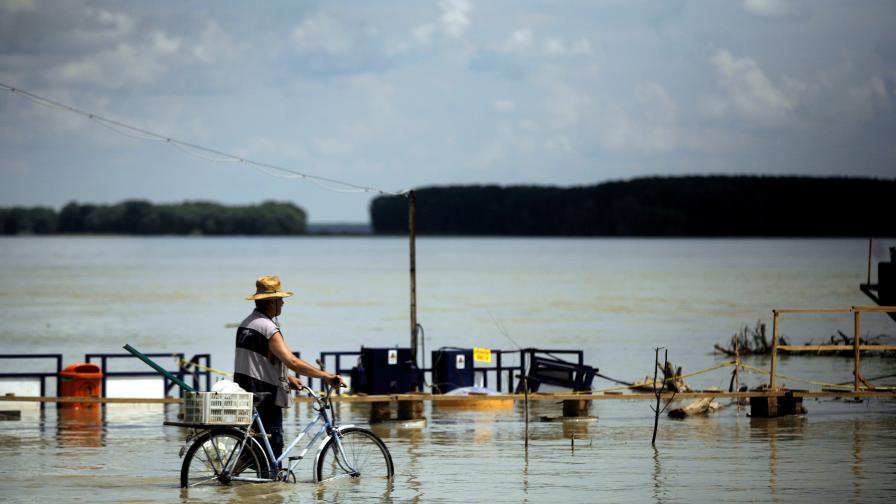 Румънец с колело по време на последните наводнения в Румъния