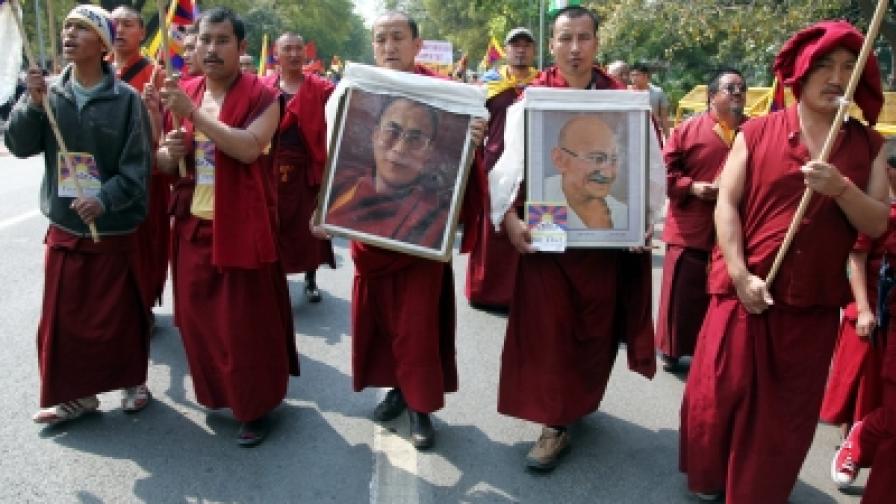Тибетски монаси изгнаници демонстрират срещу китайските власти в Ню Делхи, Индия, с портрети на Далай Лама и Махатма Ганди (снимка от 10 март 2011 г., когато се навършиха 52 години от зараждането на тибетското движение за независимост)