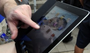 Потребител разглежда своя iPad2, чийто екран не е хибриден. Може би следващото поколение вече ще разполага с такъв.