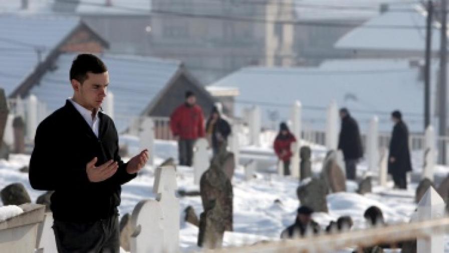 Млад мъж се моли на гробището в Нови Пазар, Сърбия