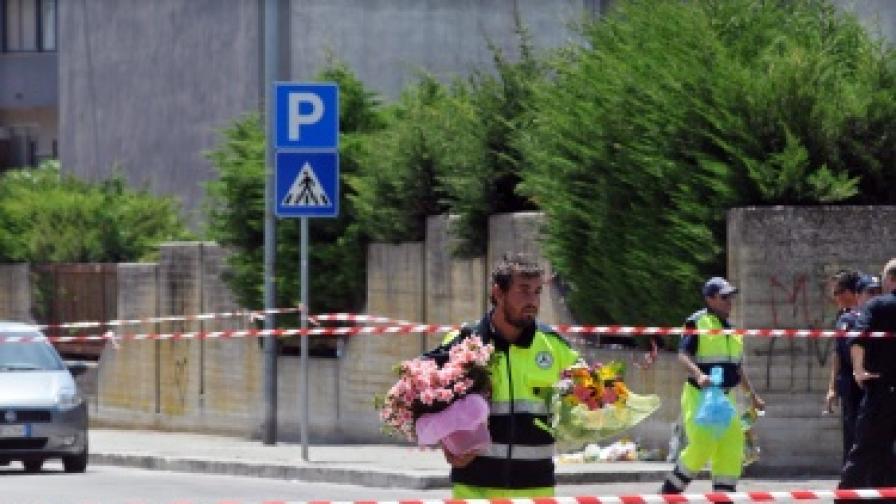 Полицай носи цветя към мястото на атентата, в който загина 16-годишно момиче
