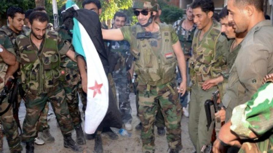 Войници от сирийската армия горят бунтовнически флаг в Алепо