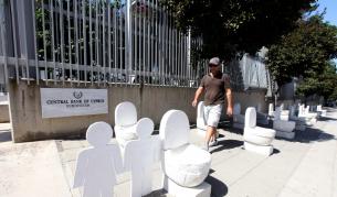 Тоалетни и надгробни плочи пред входа на централната банка на Кипър